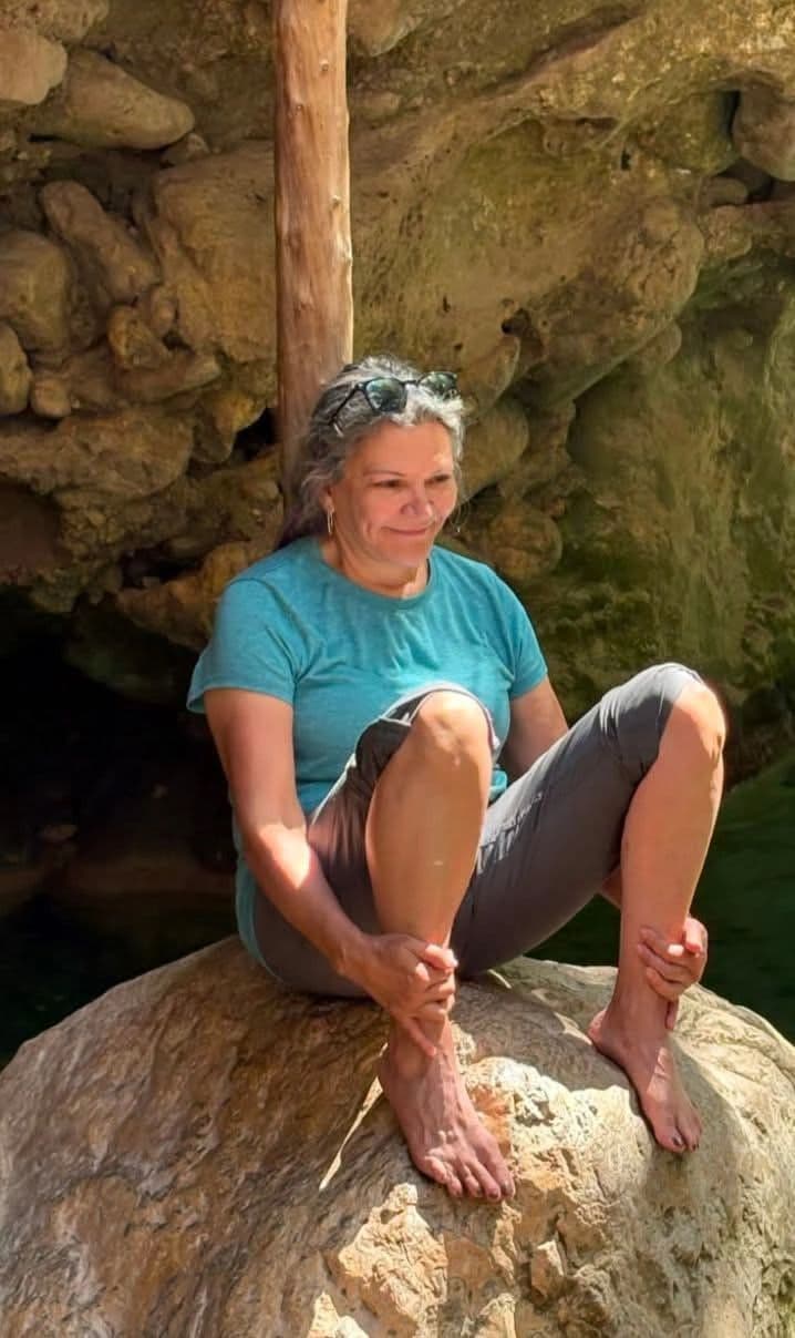 Donna seated on a rock in the Botswana bush